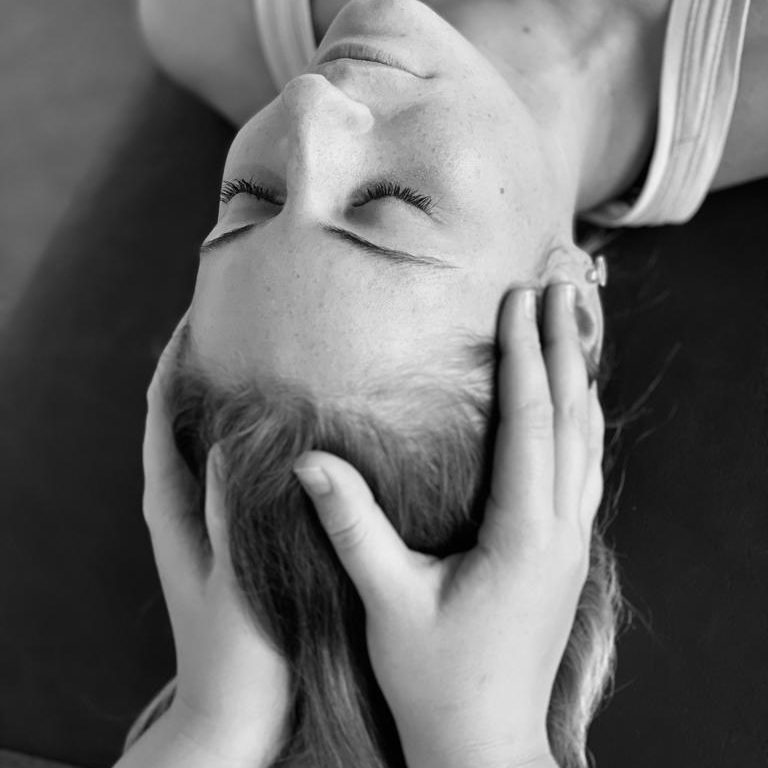 Meine Philosophie - Osteopathie Miriam Henkel, Frankfurt Frau liegt mit geschlossenen Augen, während jemand ihren Kopf osteopathisch behandelt